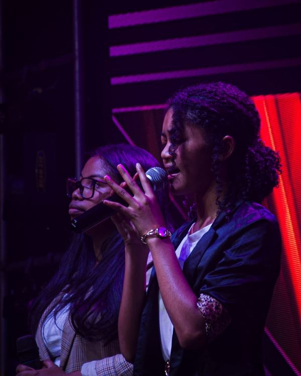 Deux chanteuses au micro sous les lumières de scène