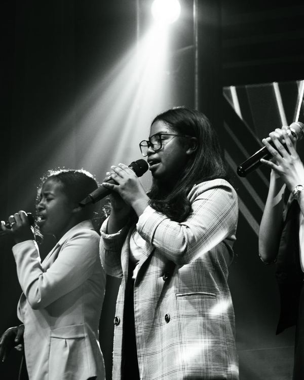 Trio vocal en noir et blanc sous les projecteurs