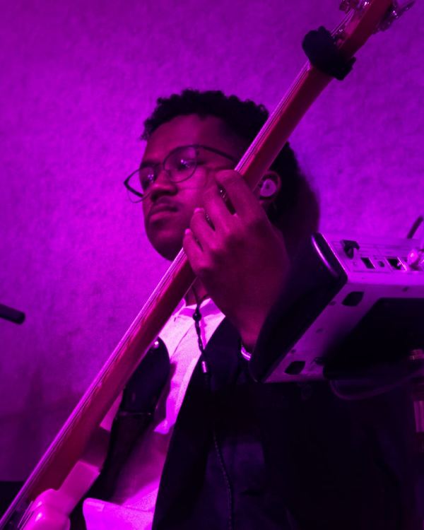 Bassiste sous les lumières violettes